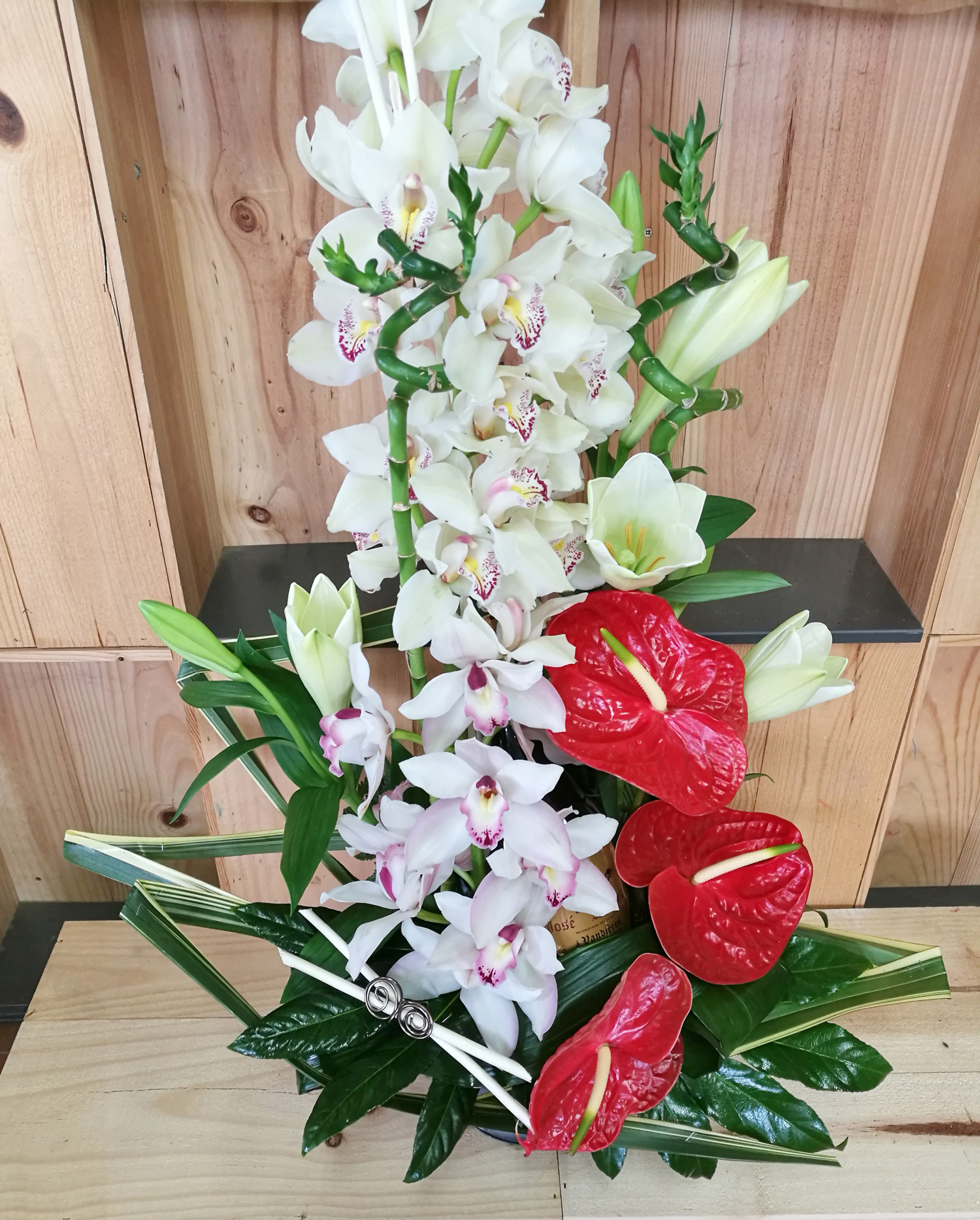 Notre fleuriste a réalisé cette composition en hauteur avec des fleurs exotiques dans les tons rouge et blanc