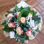 Bouquet de 10 roses bicolores, accompagnées de gypsophile, dans une bulle